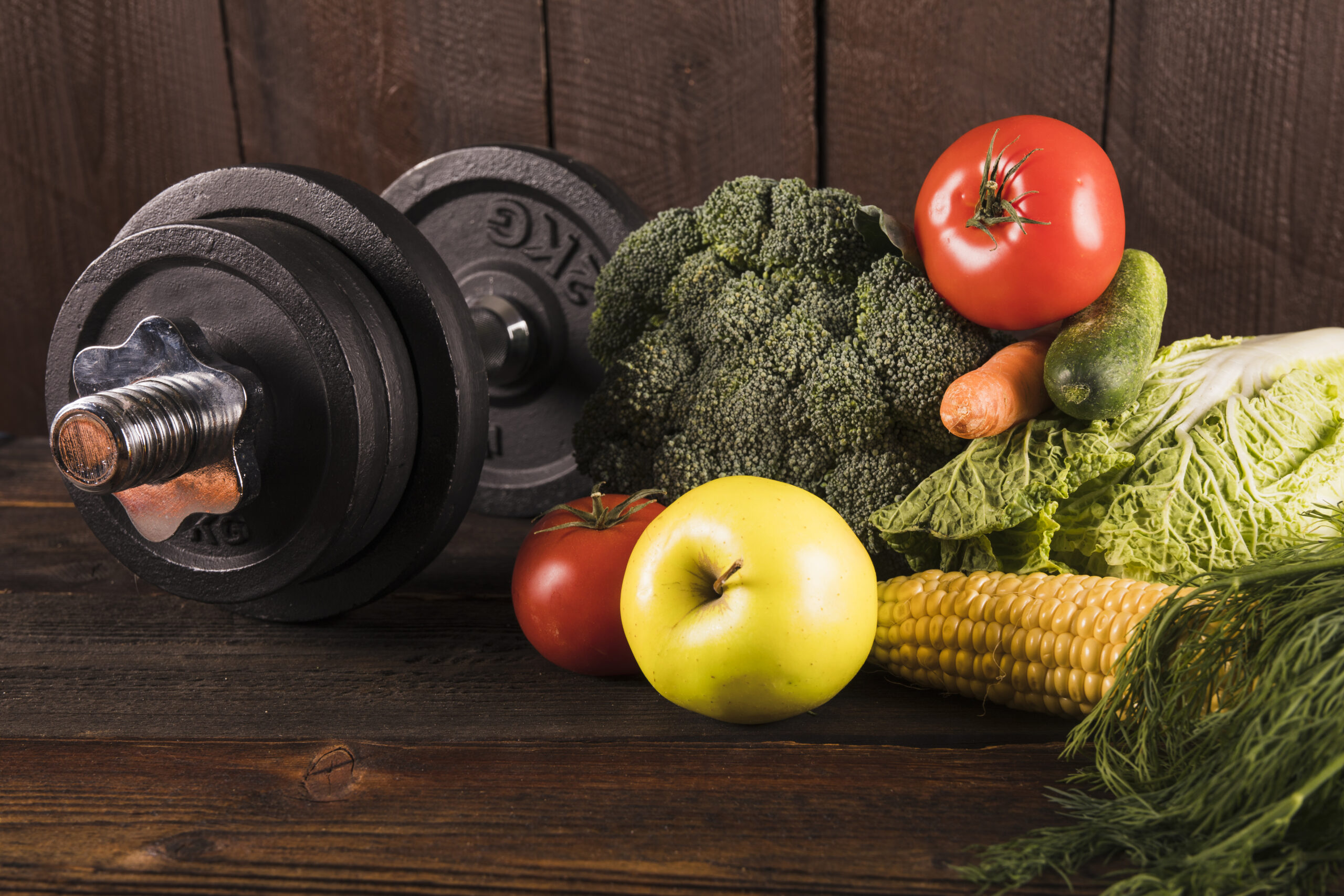 fresh-vegetables-dumbbells-wooden-background